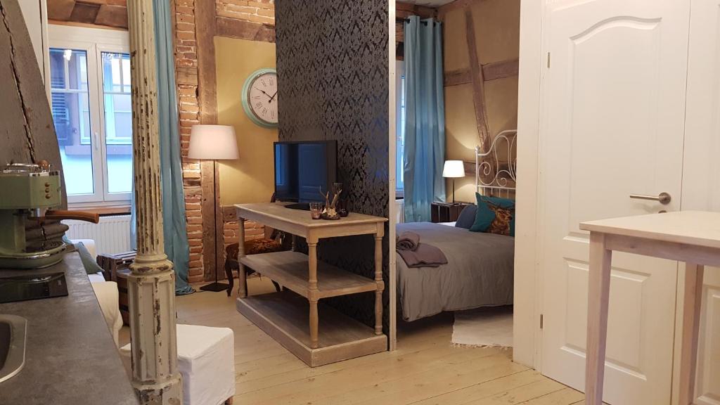 een kamer met een bed en een bureau met een televisie bij K 11 Appartements in Offenburg