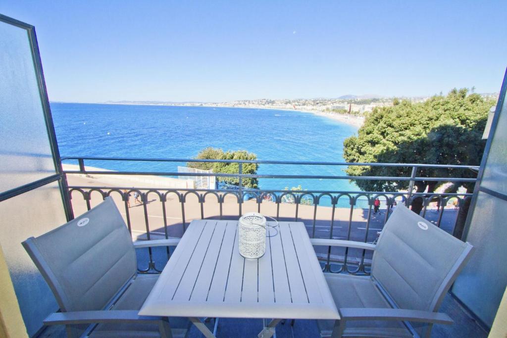 une table et des chaises sur un balcon donnant sur l'océan dans l'établissement PROMENADE HOLIDAY - ROCAMARE PROMENADE, à Nice