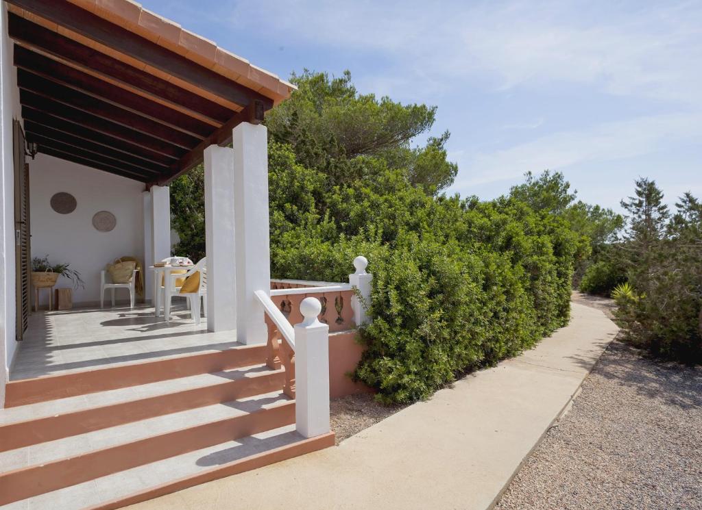 a porch of a house with a staircase and bushes at Viviendas Los Olivos - Formentera Break in Playa Migjorn