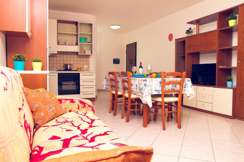 eine Küche und ein Esszimmer mit einem Tisch und Stühlen in der Unterkunft Appartamento Montenero in Pozzallo