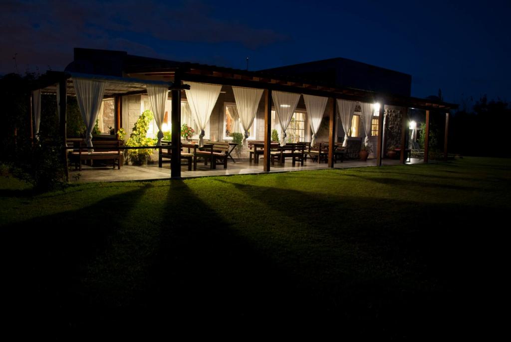 a night view of a building with picnic tables and lights at Finca La Vertiente in El Encón