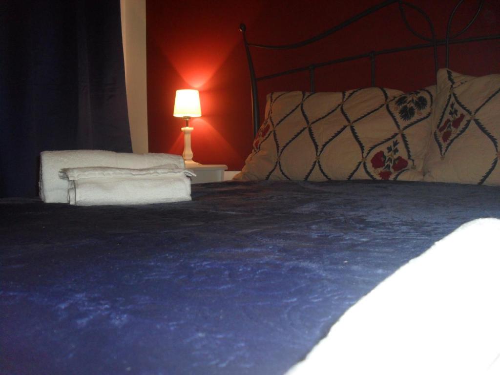 パレルモにあるAi quattro canti di cittàのベッドルーム1室(青い毛布とランプ付きのベッド1台付)