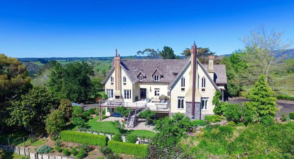 an aerial view of a large white house at The French Country House, Tauranga in Omokoroa Beach