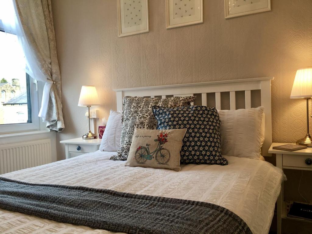 Un dormitorio con una cama con almohadas. en Dalesgate Lodge, en Skipton