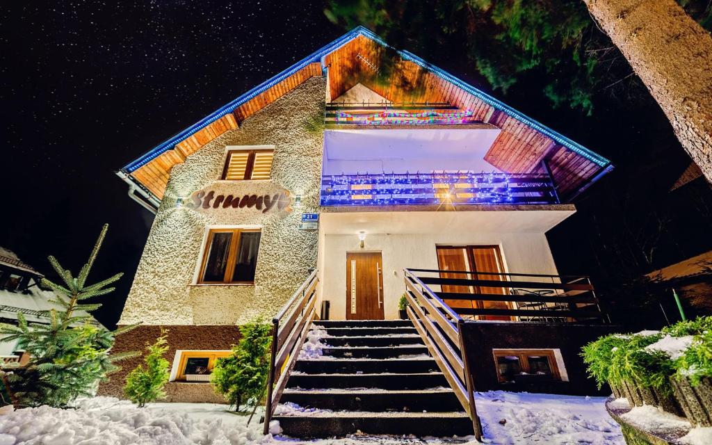 a building with stairs in the snow at night at Willa Strumyk in Karpacz