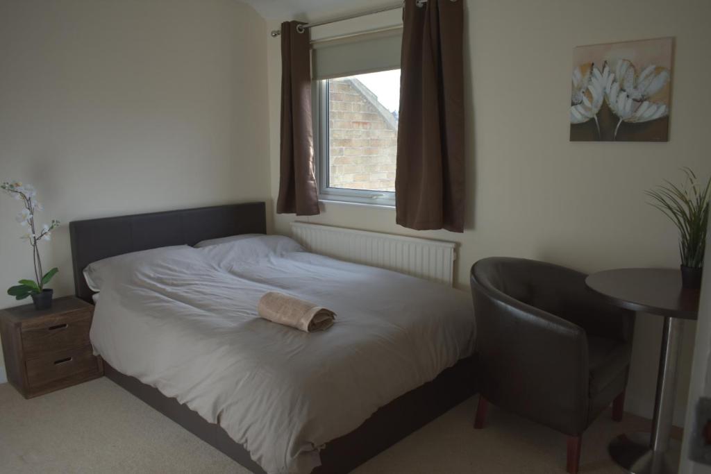 a bedroom with a bed and a chair and a window at Home and a Stay in Bristol