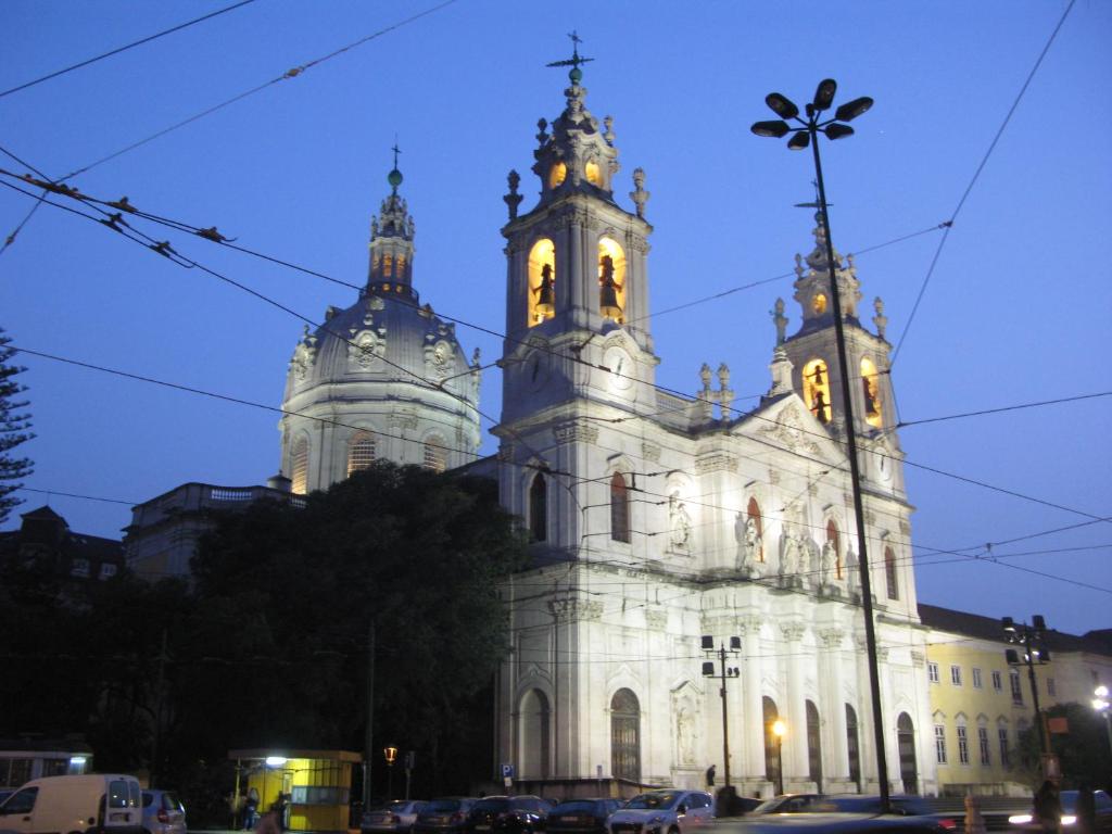 eine große weiße Kirche mit zwei Türmen in der Nacht in der Unterkunft Appartement Belvédère Estrela in Lissabon