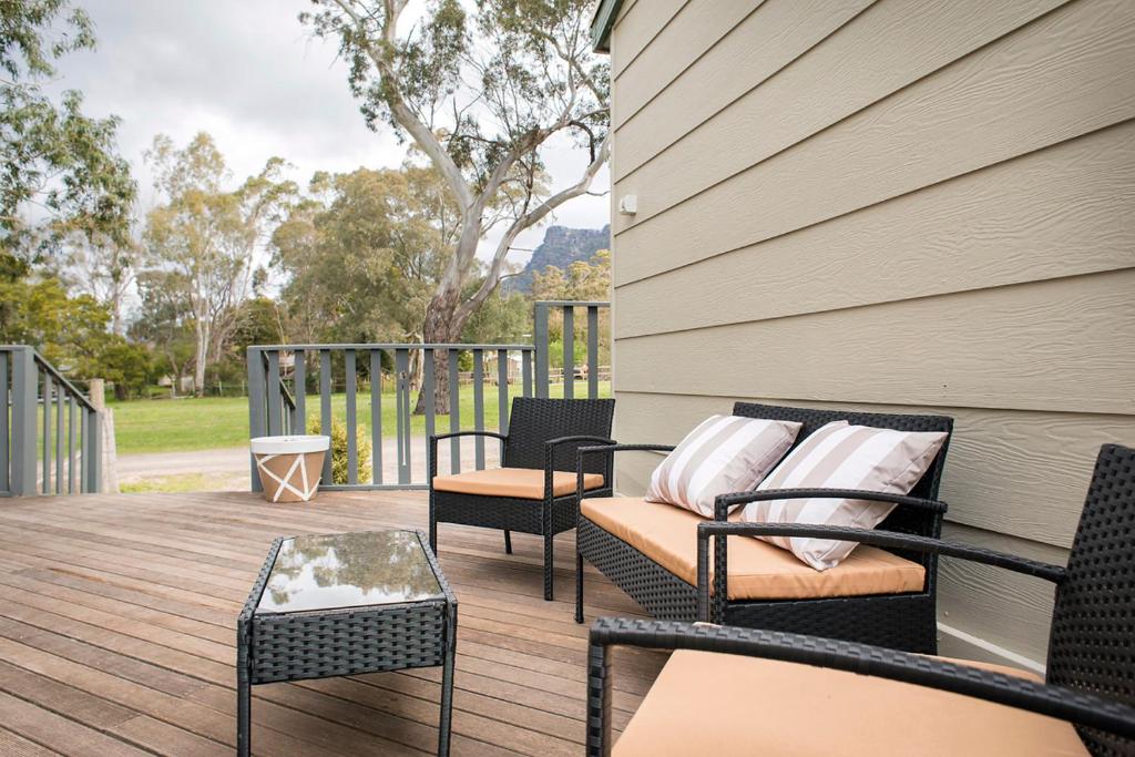 a porch with chairs and a couch on a deck at The Peaks Halls Gap in Halls Gap