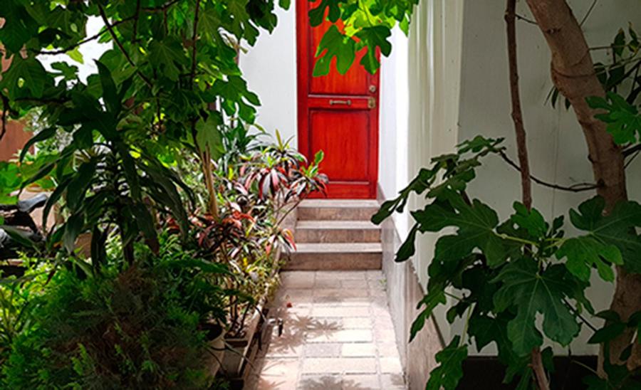 una puerta roja en un edificio con algunas plantas en Estudio en Miraflores, en Lima