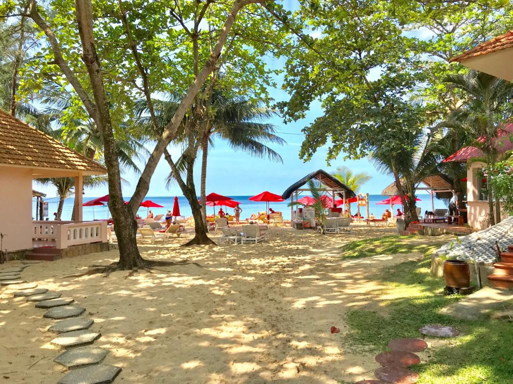 una playa con sillas y sombrillas y el océano en Hiep Thanh Resort, en Phu Quoc