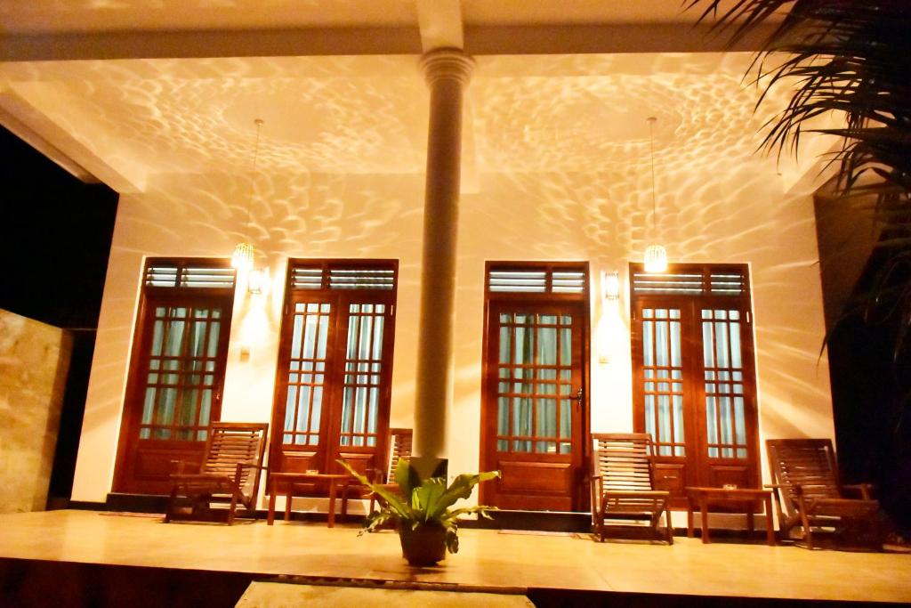 a room with chairs and windows in a building at Baby Elephant Green House in Udawalawe