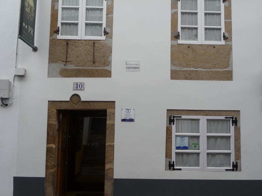 tres ventanas en el lateral de un edificio blanco en Hortas P.R., en Santiago de Compostela