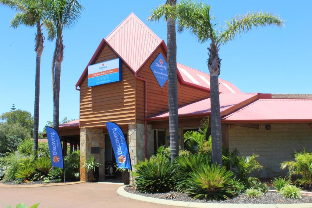 a resort with palm trees in front of a building at Discovery Parks - Bunbury Foreshore in Bunbury