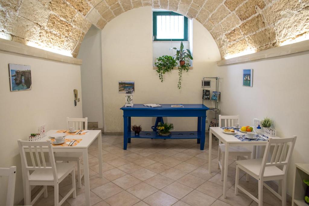 a dining room with a blue table and white chairs at 19Venti in Lecce