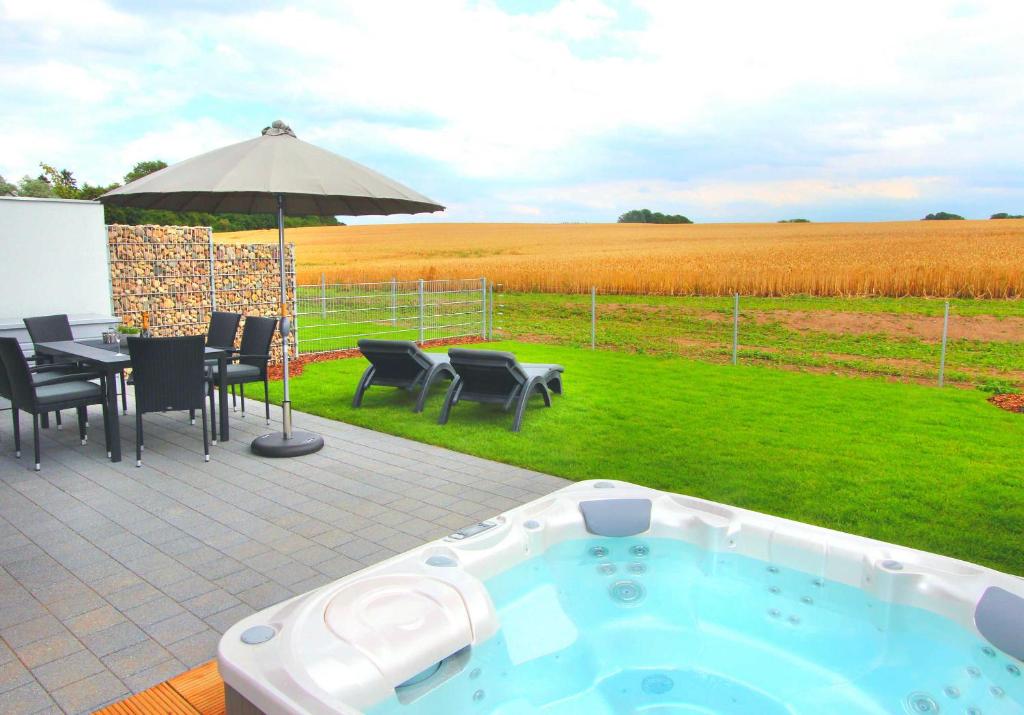 a hot tub on a patio with a table and chairs at Ferien_VILLA EASY LIVING in Göhren-Lebbin