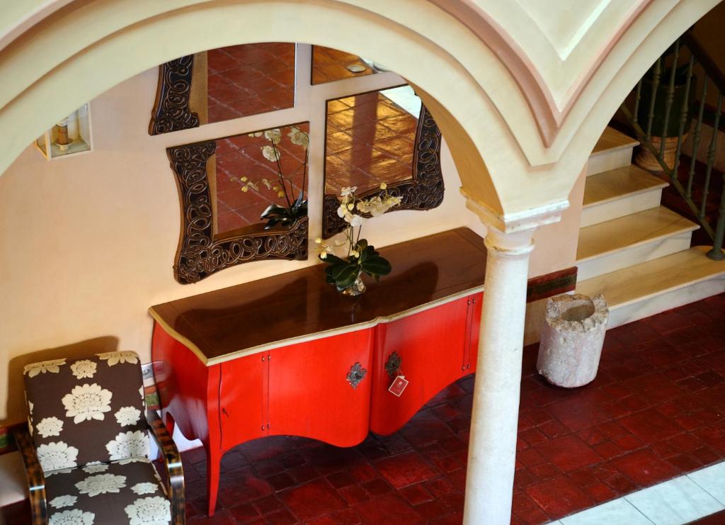 een rood bureau in een kamer met een trap bij Sacristia de Santa Ana in Sevilla