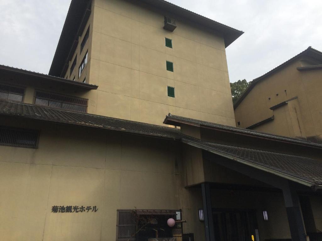 un edificio alto con escritura a un lado. en Kikuchi Kanko Hotel en Kikuchi