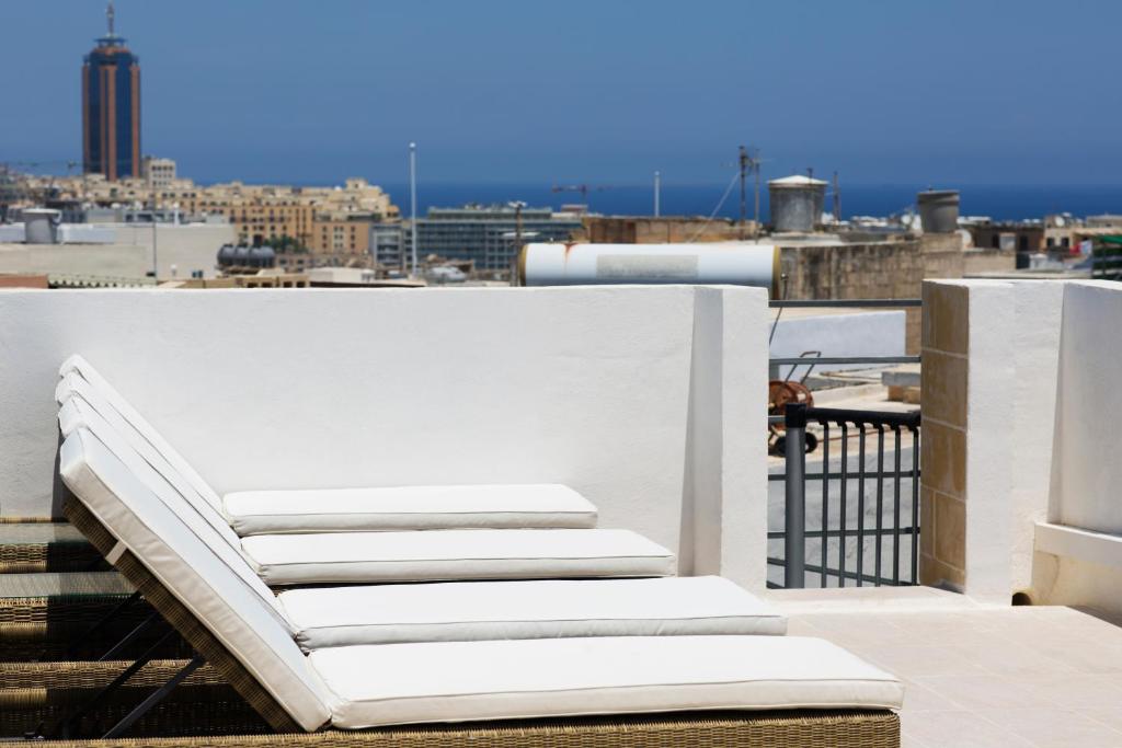 a white bed sitting on top of a roof at Maltese Town House Sliema in Sliema
