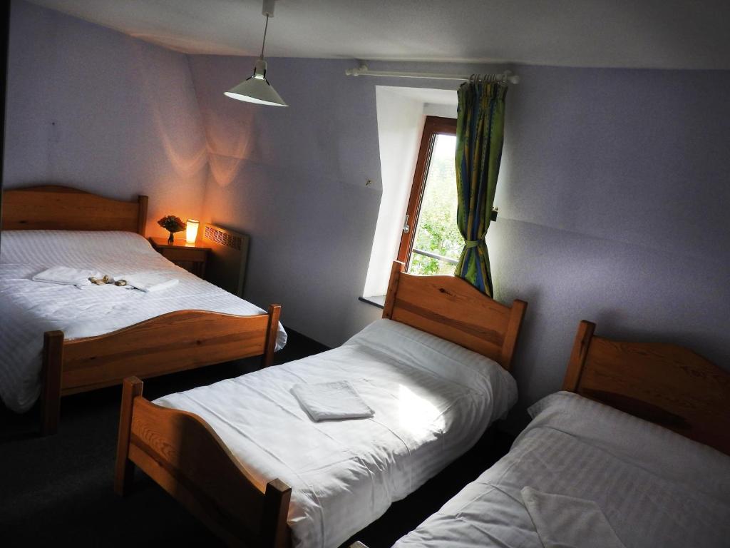 - 2 lits dans une chambre avec fenêtre dans l'établissement Aux Globe Trotters, à Murat