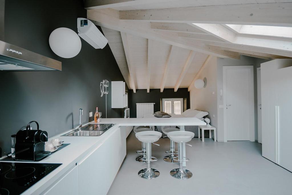 een keuken met een wit aanrecht en krukken. bij Residenza Felice in Luino