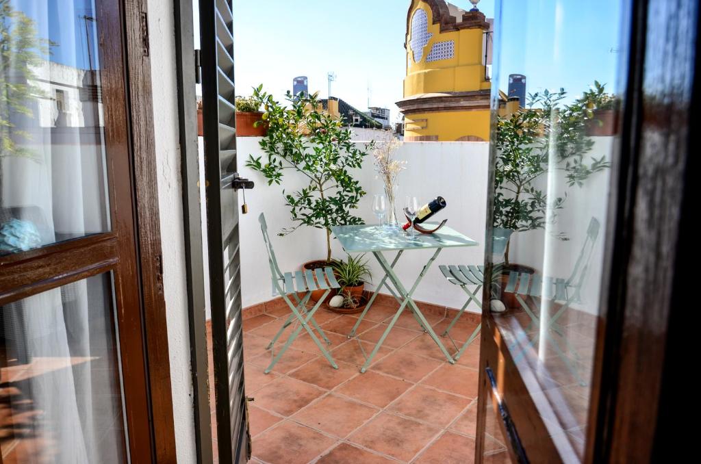 a patio with a table and chairs on a balcony at AlohaMundi Campana in Seville