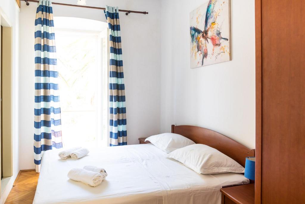 a bedroom with a bed with towels on it at Stipica Apartment in Lumbarda