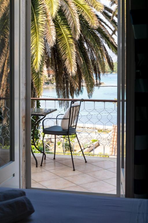 a chair sitting on a porch with a view of the ocean at Stipica Apartment in Lumbarda