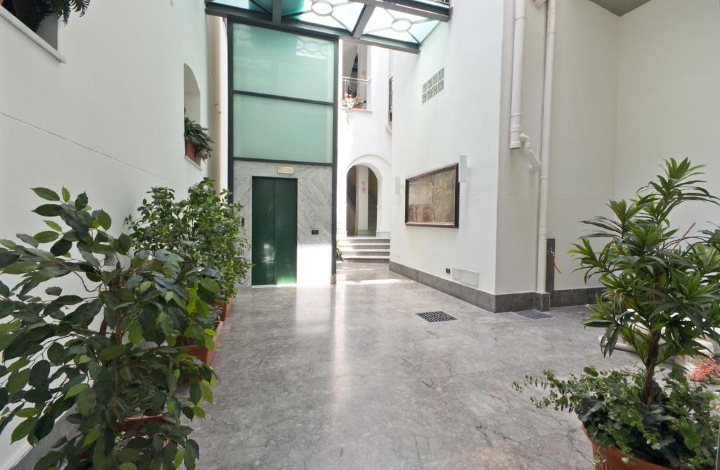 un corridoio con piante in vaso in un edificio di Palazzo Gallo a Palermo
