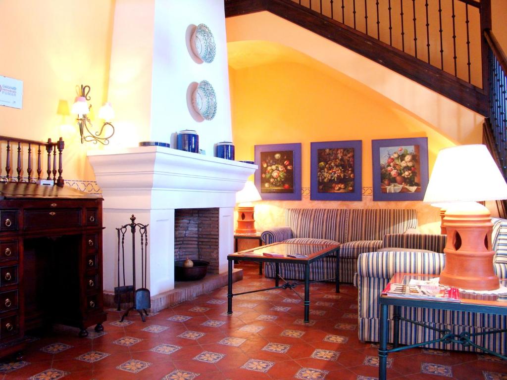 a living room with a fireplace and a table and chairs at Alojamientos Turísticos Rurales La Barataria in Titulcia