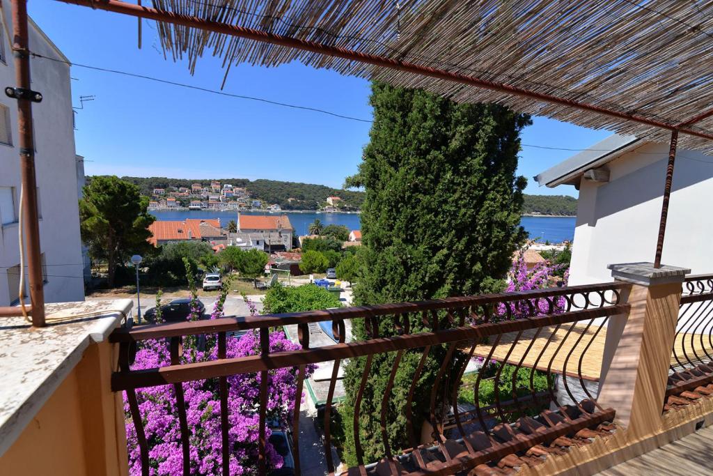 uma vista da varanda de uma casa com flores roxas em Nina em Mali Lošinj