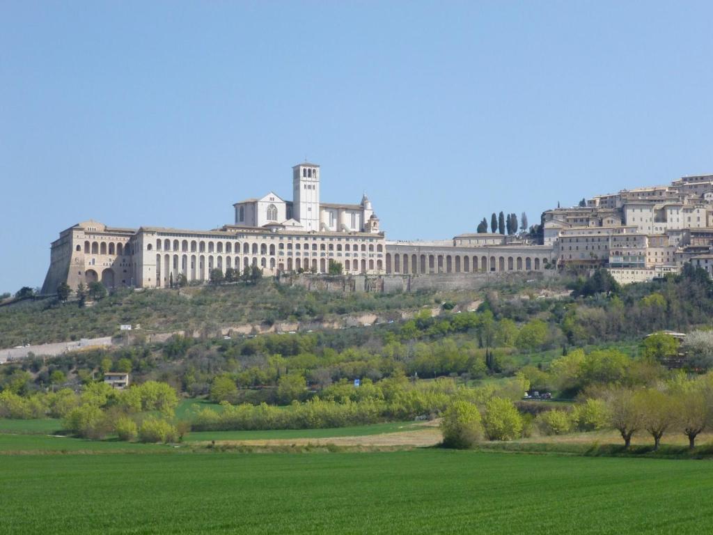 un gran edificio en una colina con un campo verde en Casa Vacanze Roberta, en Rivotorto