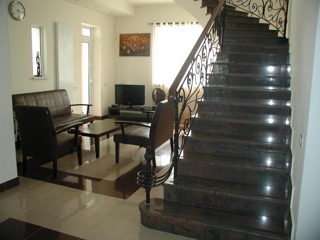 a staircase in a living room with a couch and a table at Hotel Grig in Yerevan