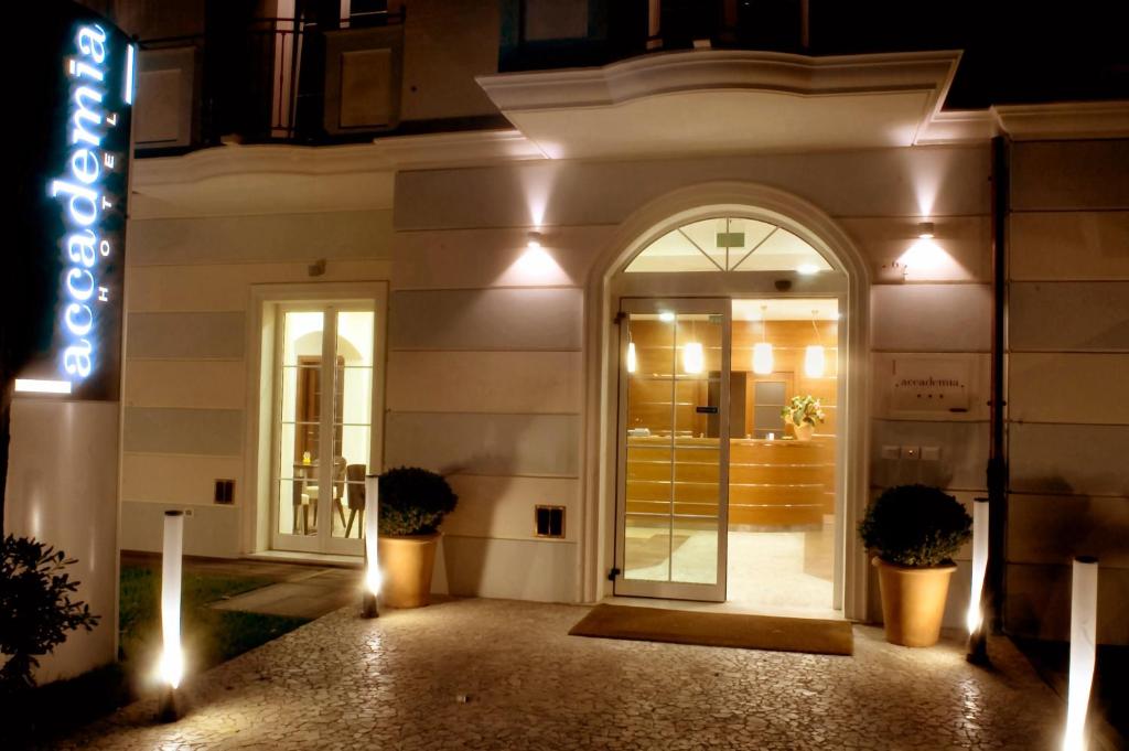 a store front at night with a sign in front at Accademia Hotel in Rimini