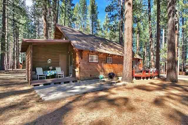 eine Blockhütte inmitten eines Waldes in der Unterkunft Hank Monk Chalet in South Lake Tahoe