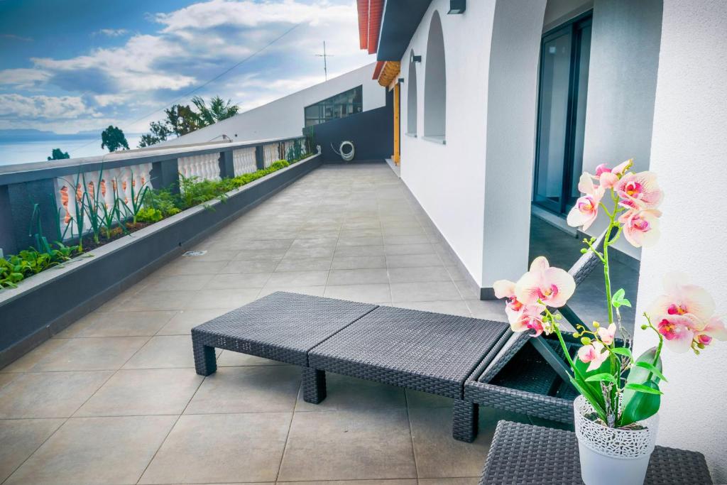 eine Bank auf dem Balkon eines Gebäudes mit Blumen in der Unterkunft Barreiros House in Funchal