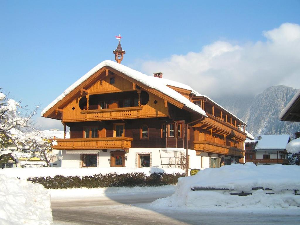un gran edificio de madera con nieve. en Pension Regina en Mayrhofen