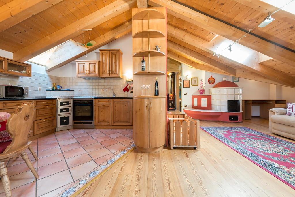 Alpino Charme Apartments في بيو: مطبخ كبير مع دواليب خشبية وغرفة معيشة