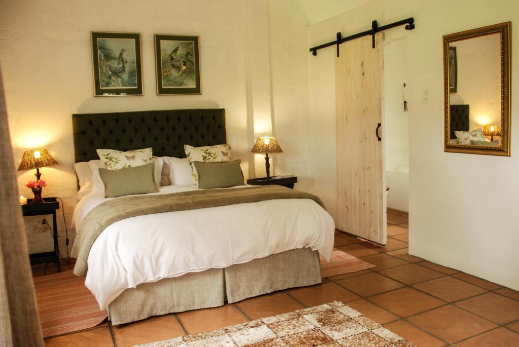 a bedroom with a large bed and a bathroom at Beverley Country Cottages in Dargle