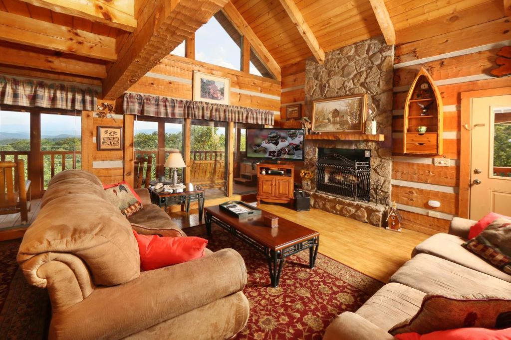 ein Wohnzimmer mit einem großen Steinkamin in einer Hütte in der Unterkunft A Walk in the Clouds in Sevierville