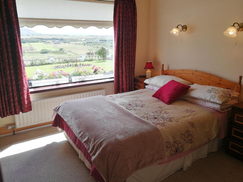 a bedroom with a bed and a large window at The Three Arches in Louisburgh