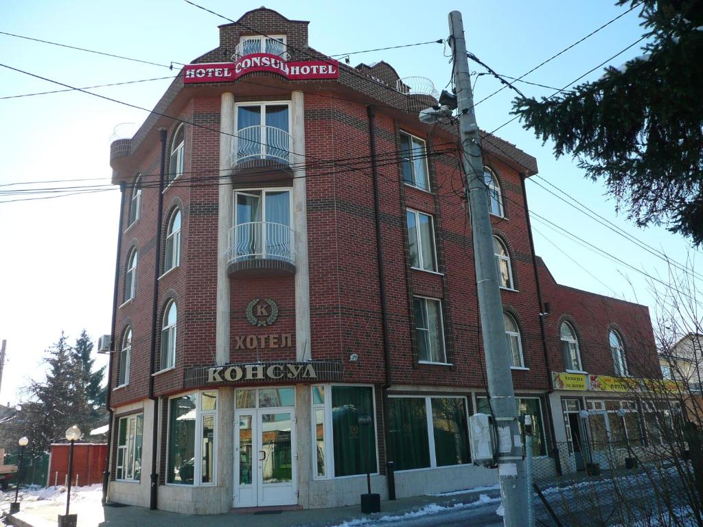 un bâtiment en briques rouges au coin d'une rue dans l'établissement Hotel Consul, à Sofia