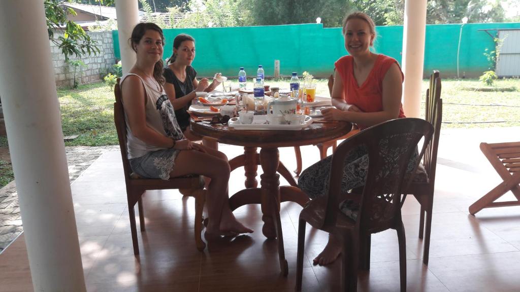 three women sitting around a table in a porch at Hotel Nimjaya in Udawalawe