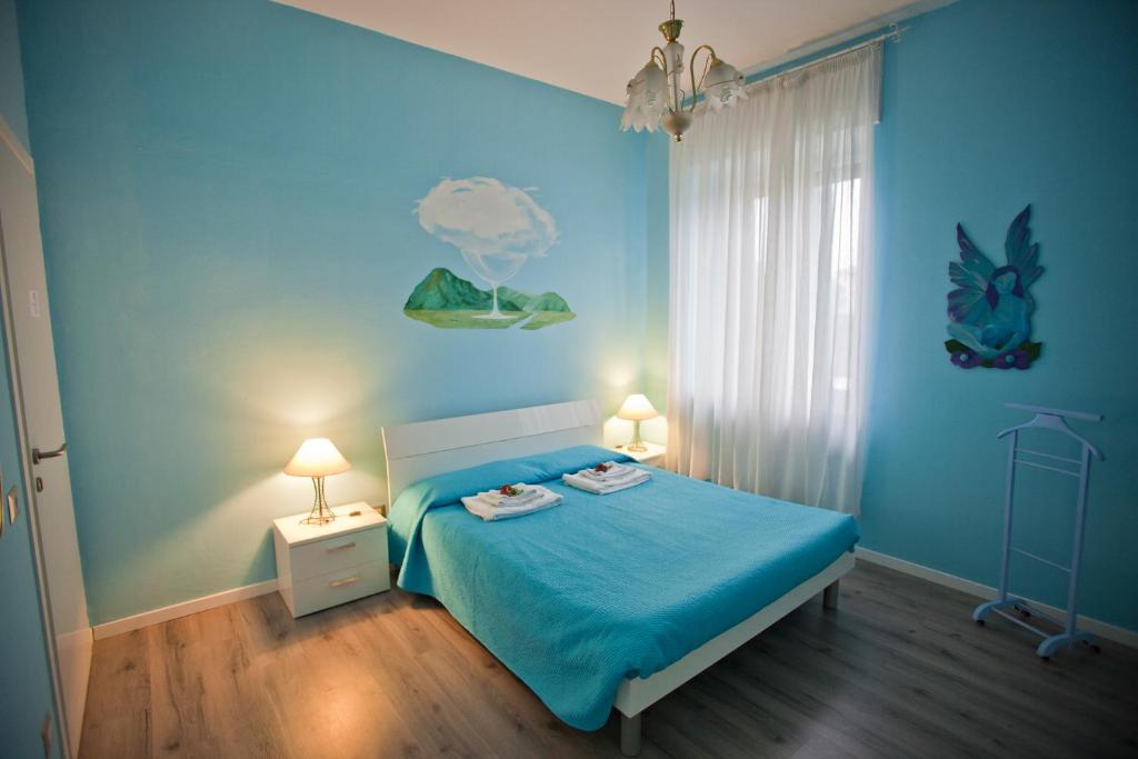 1 dormitorio azul con 1 cama y 2 lámparas en I Tre Arcangeli LT, en Verona