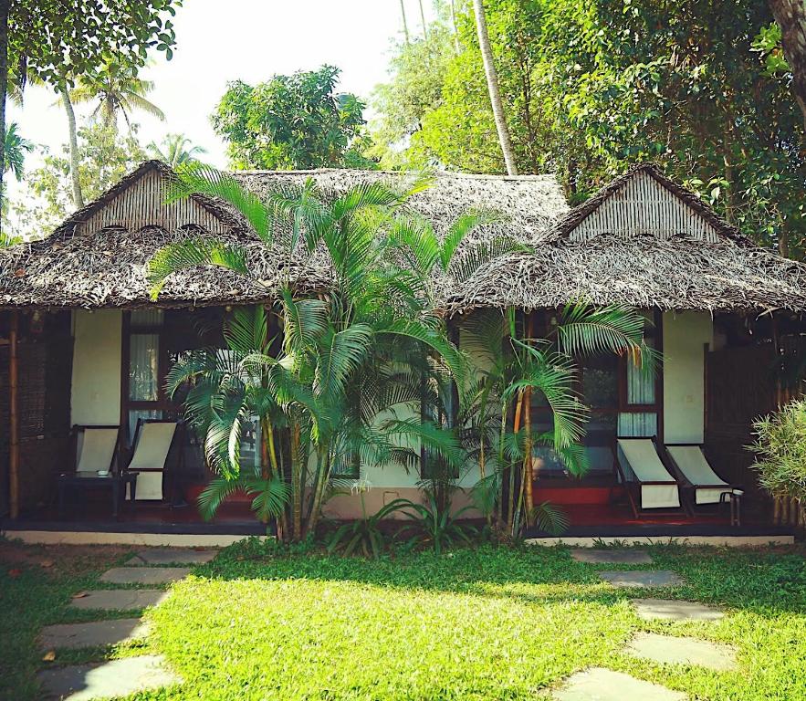 a house with chairs and trees in front of it at Les 3 Elephants in Cherai Beach