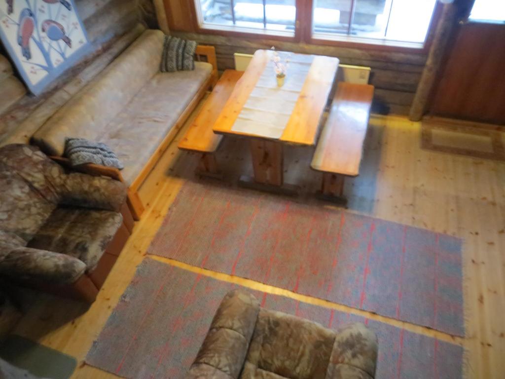 uma sala de estar com uma mesa de madeira e um sofá em Hakamajat Cottages em Syöte