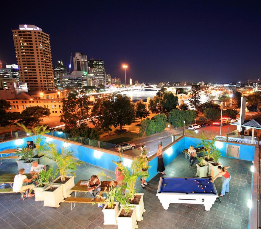 a rooftop pool with a view of the city at night at Chill Backpackers in Brisbane
