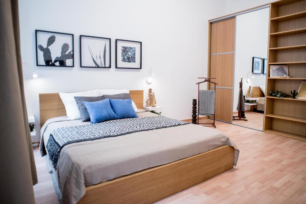 ブダペストにあるHigh Trees Apartmentのベッドルーム(青い枕の大型ベッド1台付)