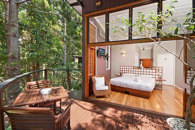 Zimmer mit einem Bett und einem Tisch auf dem Balkon in der Unterkunft Azabu Retreat & Spa in Byron Bay