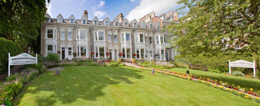 a large white house with a large lawn in front of it at Wheatlands Lodge Hotel in York