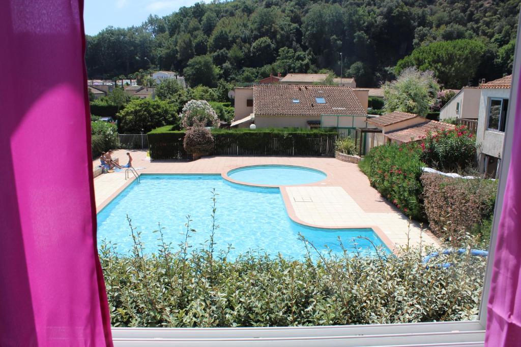 Elle offre une vue sur la piscine depuis sa fenêtre. dans l'établissement Résidence Cap Azur Appartement 217, à Villeneuve-Loubet